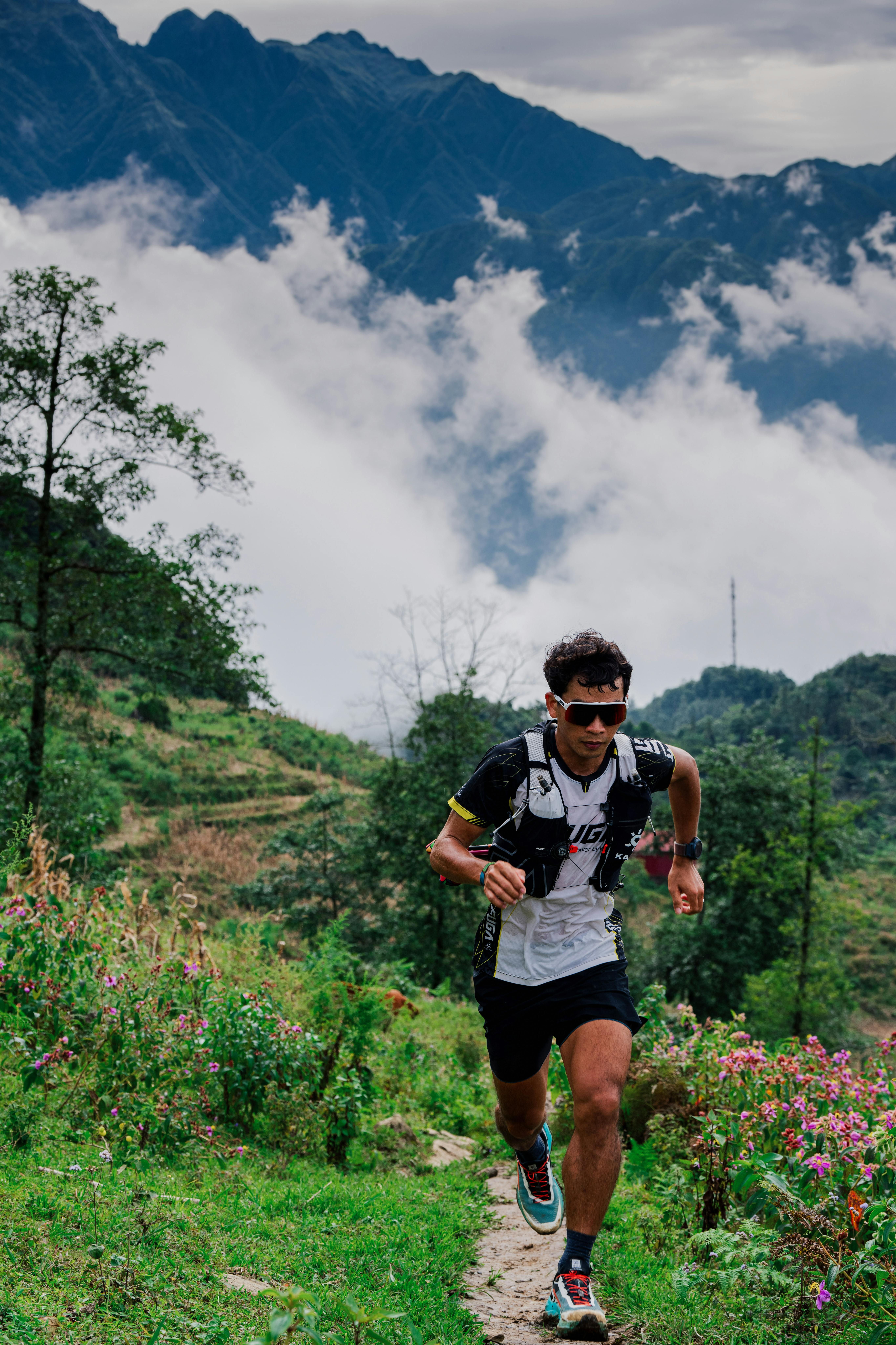 Trail runner on a mountain path wearing sport sunglasses