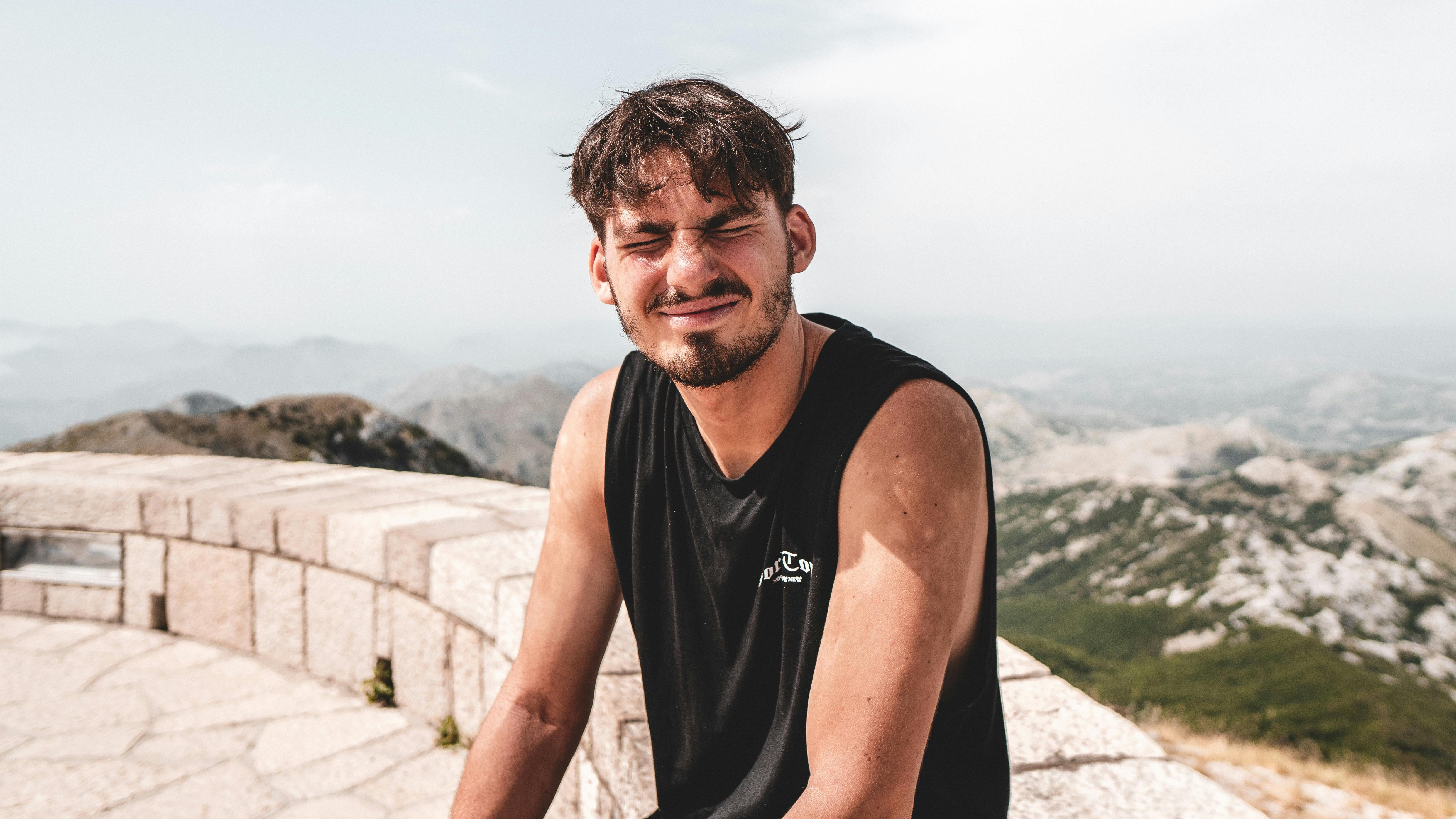 Hiker on a ridgeline in wind, squinting